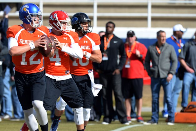 Jan 20, 2014; Fairhope, AL, USA; South Squad quarterback David Fales of San Jose State (12) , quarterback Derek Carr of Fresno State (4) and quarterback Jimmy Garoppolo of Eastern Illinois (10) run through drills during practice at Fairhope Municipal Stadium. Mandatory Credit: John David Mercer-USA TODAY Sports