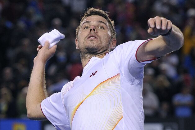 Stanislas Wawrinka of Switzerland throws a wristband to the spectators after defeating Novak Djokovic of Serbia in their quarterfinal at the Australian Open tennis championship in Melbourne, Australia, Tuesday, Jan. 21, 2014.(AP Photo/Andrew Brownbill)