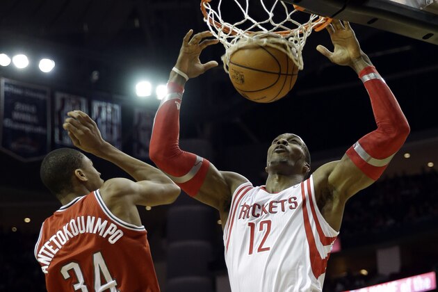 Houston Rockets' Dwight Howard (12) dunks the ball as Milwaukee Bucks' Giannis Antetokounmpo (34) defends during the third quarter of an NBA basketball game, Saturday, Jan. 18, 2014, in Houston. The Rockets won 114-104. (AP Photo/David J. Phillip)