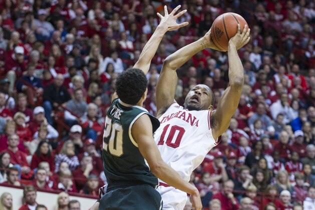 Indiana's Evan Gordon (10) puts up a shot over the defense of Michigan State's Travis Trice (20) in the second half of an NCAA college basketball game, Saturday, Jan. 4, 2014, in Bloomington, Ind. Michigan State won 73-56. (AP Photo/Doug McSchooler)
