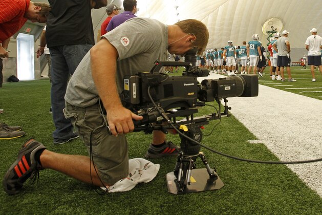 Hard Knocks crew Kevin Simkins, camera tapes the Miami Dolphins during practice at NFL football training camp in Davie, Fla., Monday, Aug. 13, 2012. (AP Photo/Alan Diaz)