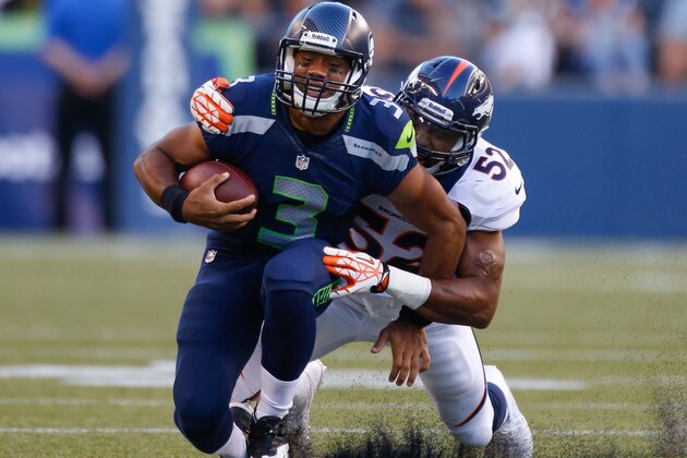 SEATTLE, WA - AUGUST 17:  Quarterback Russell Wilson #3 of the Seattle Seahawks is tackled by linebacker Wesley Woodyard #52 of the Denver Broncos at CenturyLink Field on August 17, 2013 in Seattle, Washington.  (Photo by Otto Greule Jr/Getty Images)