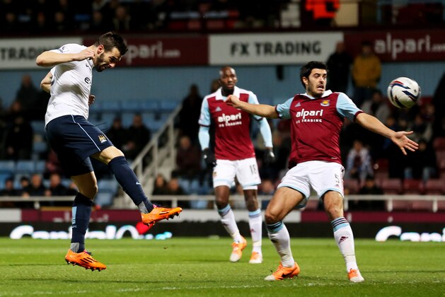 LONDON, ENGLAND - JANUARY 21:  Alvaro Negredo of Manchester City (L) beats James Tomkins of West Ham United (R) to score their first goal during the Capital One Cup Semi-Final, Second Leg match between West Ham United and Manchester City at Boleyn Ground on January 21, 2014 in London, England.  (Photo by Ian Walton/Getty Images)