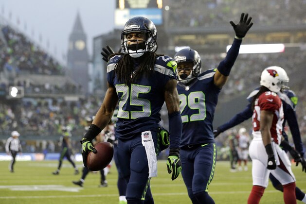 Seattle Seahawks Richard Sherman (25) comes up with the football as Seahawks' Earl Thomas (29) celebrates after Sherman intercepted an Arizona Cardinals pass in the second half of an NFL football game, Sunday, Dec. 22, 2013, in Seattle. (AP Photo/Elaine Thompson)