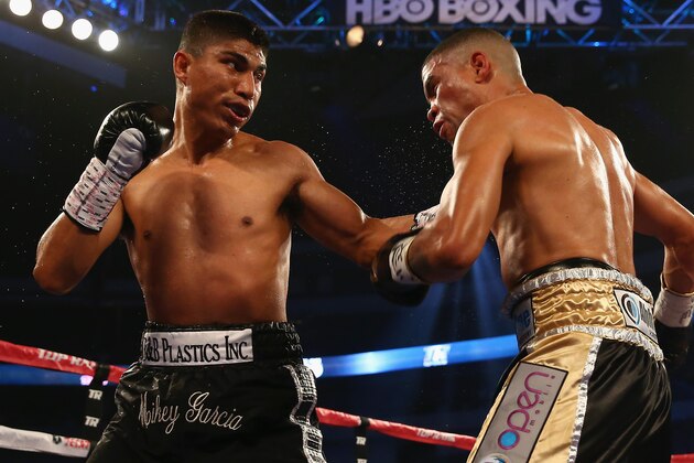 DALLAS, TX - JUNE 15:  (L-R) Mikey Garcia connects with a left to the face of Juan Manuel Lopez during their Vacant WBO Featherweight Title bout at American Airlines Center on June 15, 2013 in Dallas, Texas. Garcia knocked out Lopez in the fourth round.  (Photo by Tom Pennington/Getty Images)