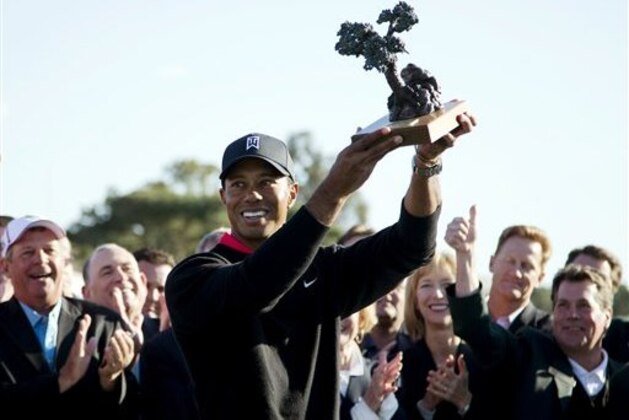 Tiger Woods holds up the trophy after winning the Farmers Insurance Open golf tournament at the Torrey Pines Golf Course, Monday, Jan. 28, 2013, in San Diego. Woods closed with an even-par 72 for a four-shot victory. (AP Photo/Gregory Bull)