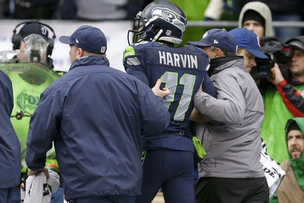 Seattle Seahawks wide receiver Percy Harvin (11) is helped off the field after being injured during the first quarter of an NFC divisional playoff NFL football game against the New Orleans Saints in Seattle, Saturday, Jan. 11, 2014. (AP Photo/Ted S. Warren)