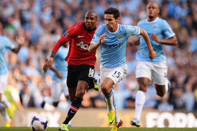 MANCHESTER, ENGLAND - SEPTEMBER 22:  Jesus Navas of Manchester City is chased by Ashley Young of Manchester United during the Barclays Premier League match between Manchester City and Manchester United at the Etihad Stadium on September 22, 2013 in Manchester, England.  (Photo by Michael Regan/Getty Images)