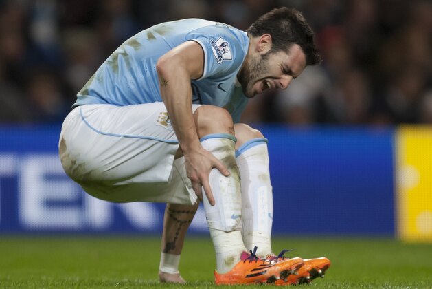 Manchester City's Alvaro Negredo falls injured to the pitch during his team's 2-1 win against Liverpool during their English Premier League soccer match at the Etihad Stadium, Manchester, England, Thursday Dec. 26, 2013. (AP Photo/Jon Super)