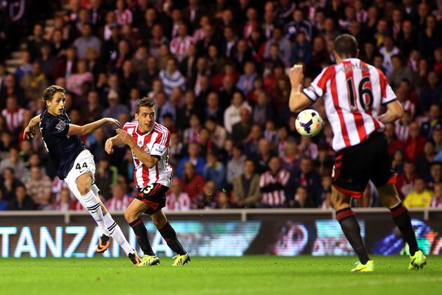 Manchester United's Adnan Januzaj, left, scores his goal past Sunderland's captain John O'Shea, right, during their English Premier League soccer match at the Stadium of Light, Sunderland, England, Saturday, Oct. 5, 2013. (AP Photo/Scott Heppell)
