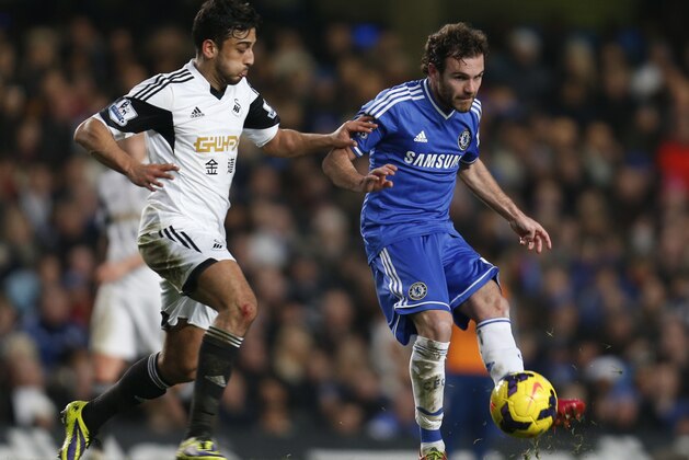 Chelsea's Juan Mata, right, of Spain controls the ball in front of Swansea City 's Neil Taylor, left, during their English Premier League soccer match at the Stamford Bridge ground in London, Thursday, Dec. 26, 2013. Chelsea won the match 1-0.(AP Photo/Lefteris Pitarakis)