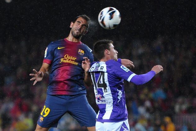 Barcelona's Martin Montoya Torralbo, left, jumps for the ball with Valladolid's Omar Ramos during a Spanish La Liga soccer match at Camp Nou stadium in Barcelona, Sunday, May 19, 2013. (AP Photo/Manu Fernandez)