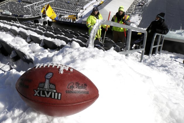 A football with the Super Bowl XLVIII logo is set on a mound of snow as an for an NFL photographer to make photos of it as workers shovel snow off the seating area at MetLife Stadium as crews removed snow ahead of Super Bowl XLVIII following a snow storm, Wednesday, Jan. 22, 2014, in East Rutherford, N.J. Super Bowl XLVIII, which will be played between the Denver Broncos and the Seattle Seahawks on Feb. 2, will be the first NFL title game held outdoors in a city where it snows. (AP Photo/Julio Cortez)
