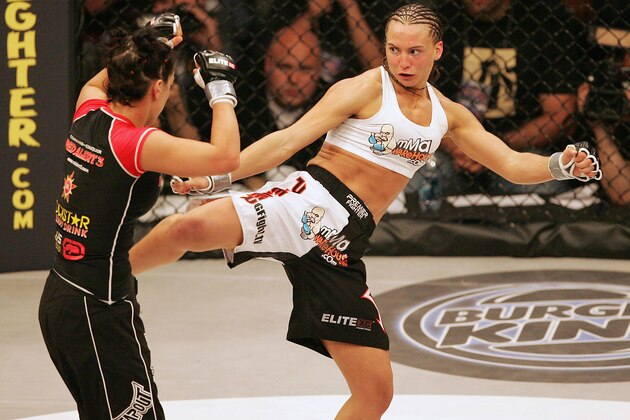 Kaitlin Young, right, kicks Gina Carano in their EliteXC 140 lbs. bout at the Prudential Center in Newark, N.J. Saturday, May 31, 2008. (AP Photo/Rich Schultz)