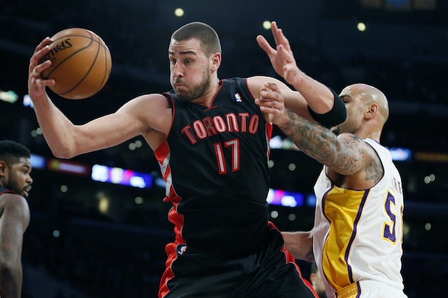 Toronto Raptors' Jonas Valanciunas, left, of Lithuania, brings in a defensive rebound in front of Los Angeles Lakers' Robert Sacre, right, during the first half of an NBA basketball game in Los Angeles, Sunday, Dec. 8, 2013. (AP Photo/Danny Moloshok)