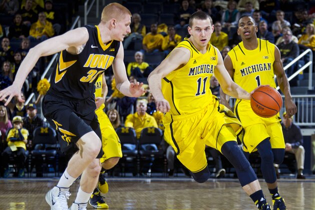 Iowa forward Aaron White (30) defends Michigan guard Nik Stauskas (11) in the first half of an NCAA college basketball game in Ann Arbor, Mich., Wednesday, Jan. 22, 2014. (AP Photo/Tony Ding)