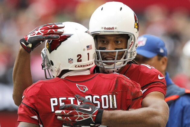 Arizona Cardinals wide receiver Larry Fitzgerald embraces teammate Patrick Peterson during the first half of an NFL football game against the St. Louis Rams , Sunday, Dec. 8, 2013, in Glendale, Ariz. (AP Photo/Rick Scuteri)