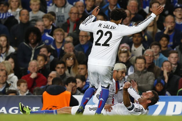 Basel's Marco Streller, lays on the pitch as he celebrates  with Mohamed Salah after scoring the winning goal during the Champions League group E soccer match between Chelsea and Basel at Stamford Bridge stadium in London, Wednesday, Sept. 18, 2013. Basel won the match 2-1. (AP Photo/Sang Tan)