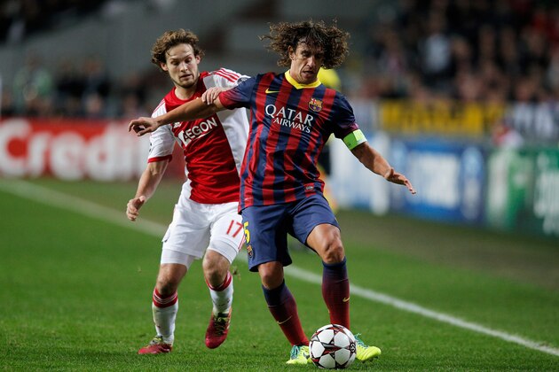 AMSTERDAM, NETHERLANDS - NOVEMBER 26:  Daley Blind of Ajax and Carles Puyol of Barcelona battle for the ball during the UEFA Champions League Group H match between Ajax Amsterdam and FC Barcelona at Amsterdam Arena on November 26, 2013 in Amsterdam, Netherlands.  (Photo by Dean Mouhtaropoulos/Getty Images)