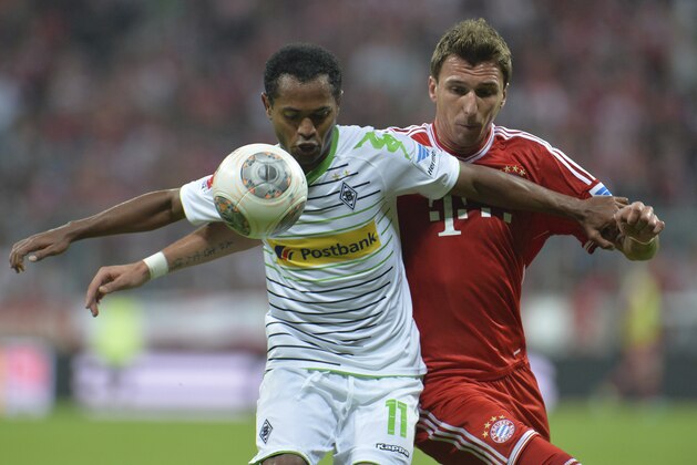 Bayern's Mario Mandzukic of Croatia, right, and Moenchengladbach's  Raffael of Brazil challenge for the ball during the German first division Bundesliga soccer match between  FC Bayern Munich and Borussia Moenchengladbach in Munich, Germany, Friday, Aug. 9, 2013. (AP Photo/Kerstin Joensson)