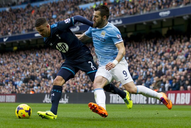 Manchester City's Alvaro Negredo, right, fights for the ball against Tottenham's Kyle Walker during their English Premier League soccer match at the Etihad Stadium, Manchester, England, Sunday Nov. 24, 2013. (AP Photo/Jon Super)