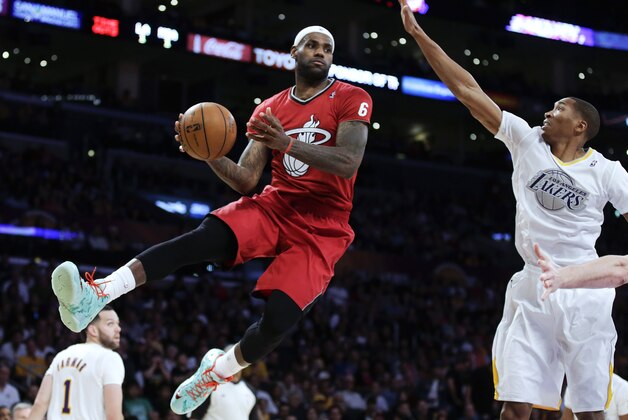 Miami Heat forward LeBron James, left, passes around Los Angeles Lakers guard Wesley Johnson during the second half of an NBA basketball game in Los Angeles, Wednesday, Dec. 25, 2013. (AP Photo/Chris Carlson)