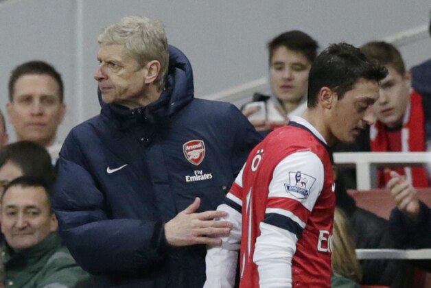 Arsenal's Mesut Ozil, right, is patted by his French manager Arsene Wenger after being substituted off during the English Premier League soccer match between Arsenal and Fulham at the Emirates Stadium in London, Saturday, Jan. 18, 2014.  (AP Photo/Matt Dunham)