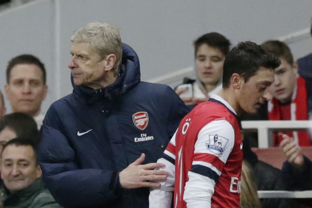 Arsenal's Mesut Ozil, right, is patted by his French manager Arsene Wenger after being substituted off during the English Premier League soccer match between Arsenal and Fulham at the Emirates Stadium in London, Saturday, Jan. 18, 2014.  (AP Photo/Matt Dunham)