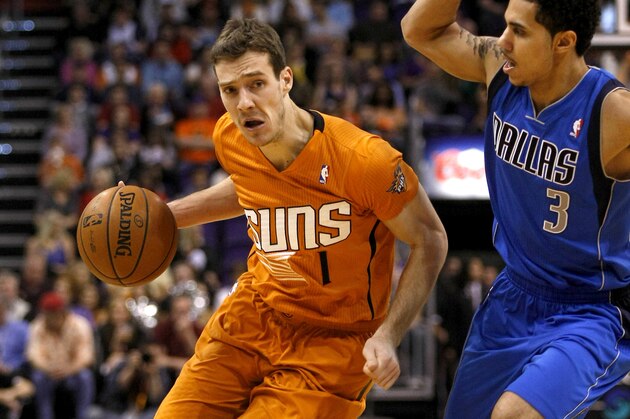 Phoenix Suns shooting guard Goran Dragic (1) drrives on Dallas Mavericks point guard Shane Larkin (3) in the fourth quarter during an NBA basketball game, Friday, Jan. 17, 2014, in Phoenix. (AP Photo/Rick Scuteri)