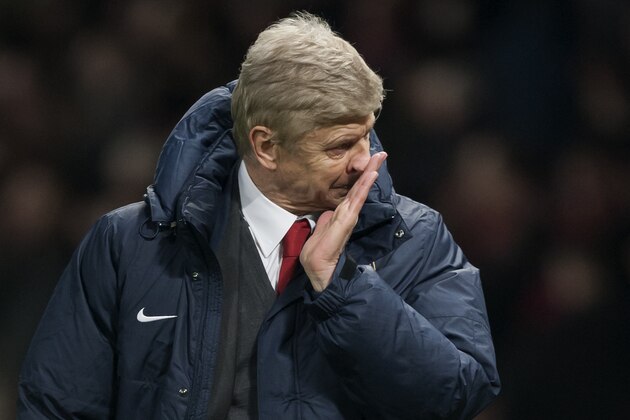 Arsenal's manager Arsene Wenger wipe his face as he walks from the pitch after his team's 1-0 loss at Manchester United in their English Premier League soccer match at Old Trafford Stadium, Manchester, England, Saturday Nov. 10, 2013. (AP Photo/Jon Super)