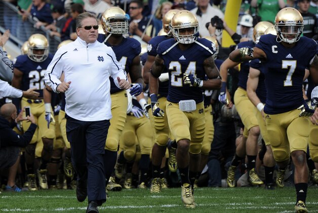 Notre Dame coach Brian Kelly runs onto the field with his team  prior to a in a NCAA college football game with Michigan State Saturday Sept. 21, 2013 in South Bend, Ind. (AP Photo/Joe Raymond)