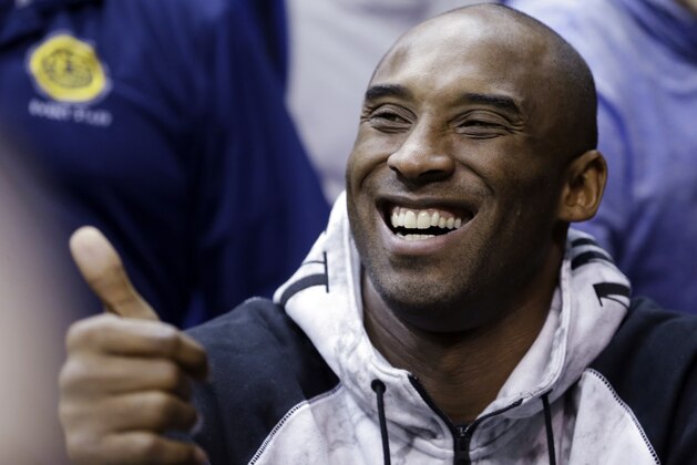 Los Angeles Lakers' Kobe Bryant gives a thumbs-up to a fan during the NCAA basketball game between Duke and Miami in Coral Gables, Fla., Wednesday, Jan. 22, 2014. (AP Photo/Alan Diaz)
