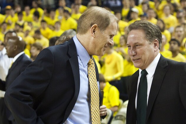 Michigan head coach John Beilein, left, speaks with Michigan State head coach Tom Izzo in the first half of an NCAA college basketball game, Tuesday, Jan. 26, 2010, in Ann Arbor, Mich. (AP Photo/Tony Ding)