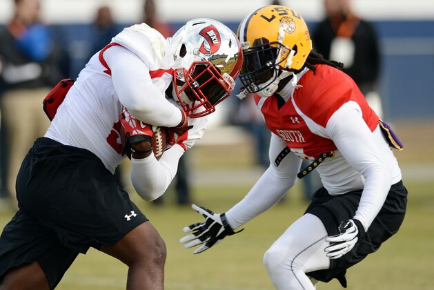 Jan 20, 2014; Fairhope, AL, USA; South Squad running back Antonio Andrews of Western Kentucky (5) carries the ball against South Squad safety Craig Loston of LSU (6) during practice at Fairhope Municipal Stadium. Mandatory Credit: John David Mercer-USA TODAY Sports