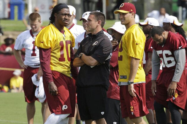 FILE - In this July 25, 2013 file photo, Washington Redskins quarterback coach, Matt LaFleur, center, talks with quarterbacks Robert Griffin III, left, and Kirk Cousins, right, on the field as they begin their training camp at the NFL football teams new practice facility in Richmond, Va. For once, Griffin looks like the healthier of the two young Redskins quarterbacks. (AP Photo/Steve Helber, File)
