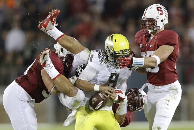 Oregon quarterback Marcus Mariota (8) fumbles as he is tackled by Stanford defensive tackle David Parry, left, linebacker A.J. Tarpley, rear, and linebacker Jarek Lancaster, right, during the third quarter of an NCAA college football game in Stanford, Calif., Thursday, Nov. 7, 2013. Stanford recovered the fumble. (AP Photo/Marcio Jose Sanchez)
