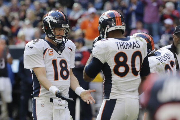 Denver Broncos' Peyton Manning (18) celebrates with Julius Thomas (80) and other teammates after he threw a pass for a touchdown against the Houston Texans during the third quarter of an NFL football game, Sunday, Dec. 22, 2013, in Houston. (AP Photo/David J. Phillip)