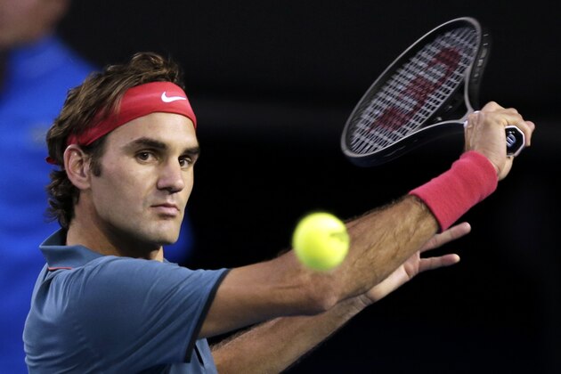 Roger Federer of Switzerland makes a backhand return to Rafael Nadal of Spain during their semifinal at the Australian Open tennis championship in Melbourne, Australia, Friday, Jan. 24, 2014.(AP Photo/Rick Rycroft)