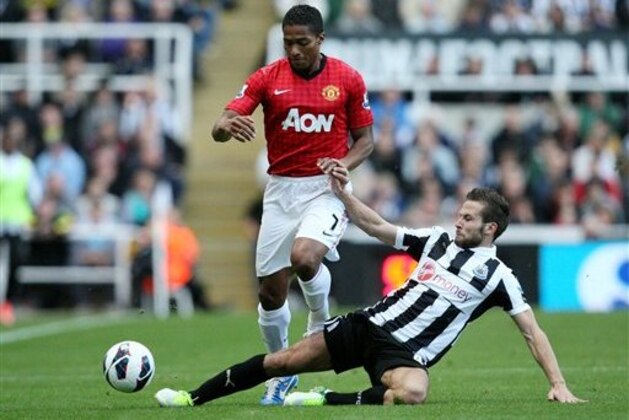 Manchester United's Antonio Valencia, left, vies for the ball with Newcastle United's Yohan Cabaye, right, during their English Premier League soccer match at the Sports Direct Arena, Newcastle, England, Sunday, Oct. 7, 2012. (AP Photo/Scott Heppell)