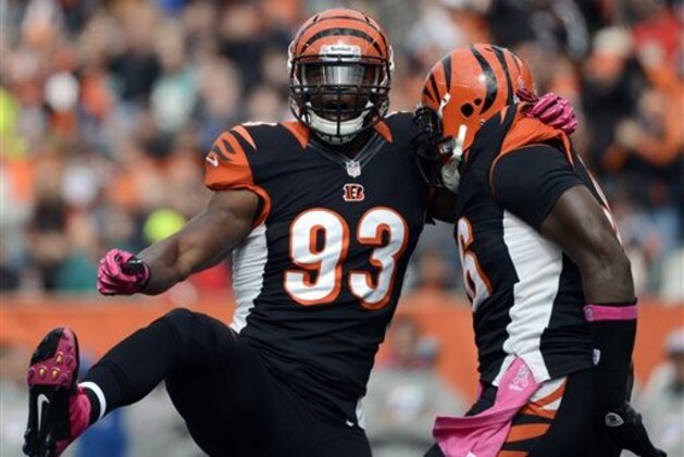 Cincinnati Bengals defensive end Michael Johnson (93) celebrates with defensive end Carlos Dunlap after sacking Miami Dolphins quarterback Ryan Tannehill in the first half of an NFL football game on Sunday, Oct. 7, 2012, in Cincinnati. (AP Photo/Michael Keating)