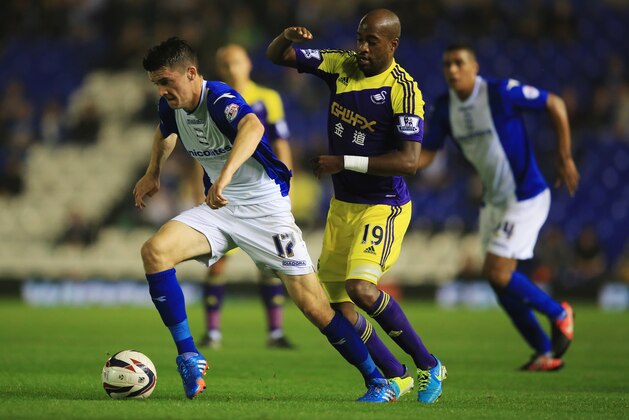 BIRMINGHAM, ENGLAND - SEPTEMBER 25:  Callum Reilly of Birmingham City evades Dwight Tiendalli of Swansea City during the Capital One Cup Third Round match between Birmingham City and Swansea City at St Andrews on September 25, 2013 in Birmingham, England.  (Photo by Richard Heathcote/Getty Images)