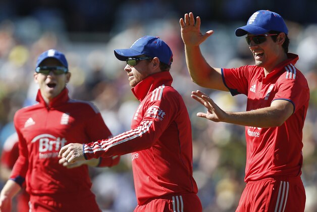 England's Ian Bell, center, is congratulated by team mates Alastair Cook, right, and Eoin Morgan after he caught out Australia's Shaun Marsh during their one day international cricket match in Perth, Australia, Friday, Jan. 24, 2014. (AP Photo/Theron Kirkman)