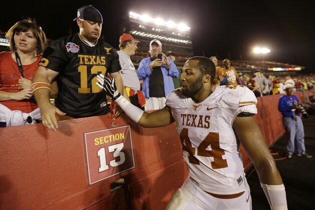 Texas defensive end Jackson Jeffcoat (44) celebrates with fans after his team's 31-30 victory over Iowa State in an NCAA college football game, Thursday, Oct. 3, 2013, in Ames, Iowa. (AP Photo/Charlie Neibergall)