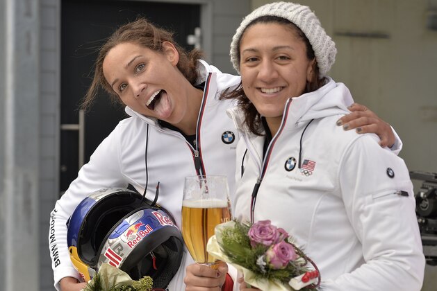 Elana Meyers and Lolo Jones of the USA, from right, pose for photographers after their second place in the women's Bobsled  World Cup race in Winterberg, Germany, on Sunday, Jan. 5, 2014. (AP Photo/Martin Meissner)
