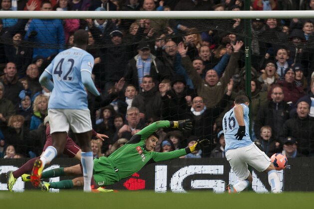 Manchester City's Sergio Aguero, right, scores the first of his 3 goals past Watford's goalkeeper Jonathan Bond during their English FA Cup fourth round soccer match at The City of Manchester Stadium, Manchester, England, Saturday, Jan. 25, 2014. (AP Photo/Jon Super)