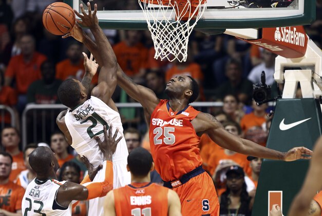 Syracuse's Rakeem Christmas (25) blocks Miami's Erik Swoope (21) during the first half of an NCAA college basketball game in Coral Gables, Fla., Saturday, Jan. 25, 2014. (AP Photo/J Pat Carter)
