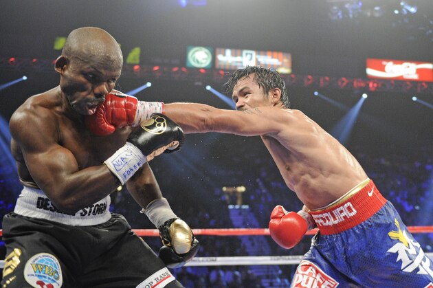 Manny Pacquiao, from the Philippines, right, lands a left to the head of Timothy Bradley, from Palm Springs, Calif., in their WBO world welterweight title fight Saturday, June 9, 2012, in Las Vegas. (AP Photo/Chris Carlson)
