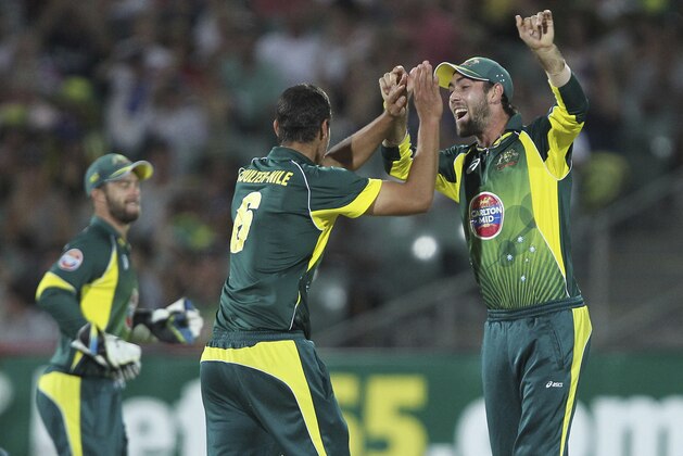 Australia's Nathan Coulter-Nile left and Glenn Maxwell right celebrate the wicket of England's Jos Buttler during their One Day International cricket match against Australia in Adelaide, Australia, Sunday Jan. 26, 2014.(AP Photo/James Elsby)