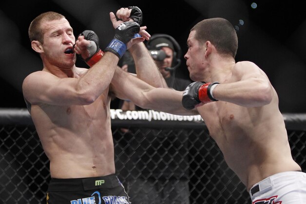 Nate Diaz, right, punches Donald Cerrone during the first round of their UFC lightweight mixed martial arts match Friday, Dec. 30, 2011, at The MGM Grand Garden Arena in Las Vegas. (AP Photo/Eric Jamison)