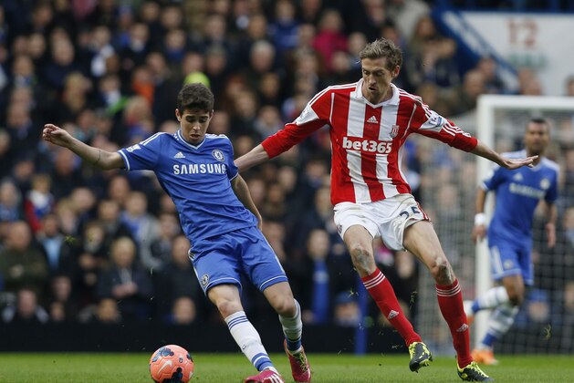 Chelsea's Oscar, left, competes with Stoke City's Peter Crouch during their English FA Cup fourth round soccer match at Stamford Bridge, London, Sunday, Jan. 26, 2014. (AP Photo/Sang Tan)